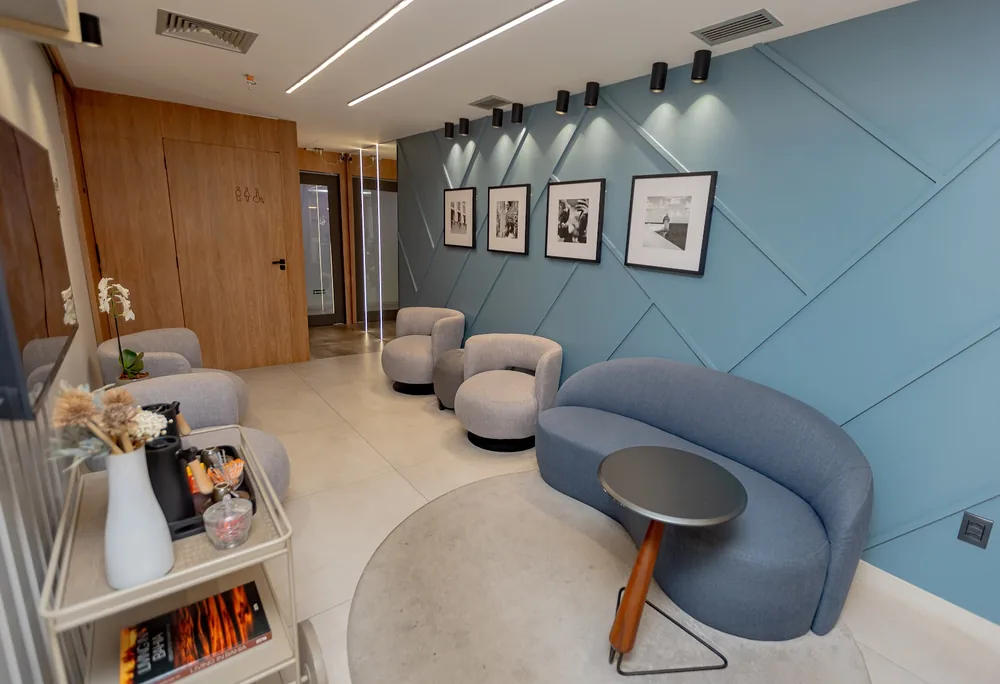 Sala de espera com poltronas e parede de acento azul